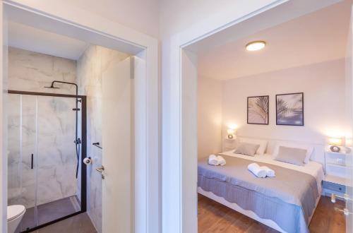 a white bedroom with a bed and a shower at Villa Bellevue in Cavtat