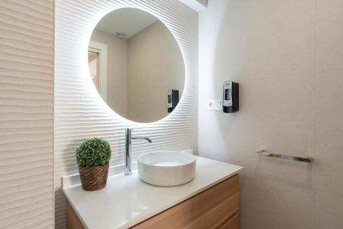 a bathroom with a sink and a mirror at La Cala Beach by ELE Apartments in Cala del Moral