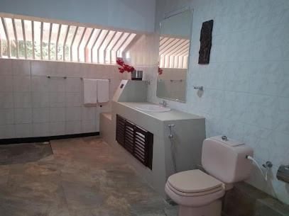 a bathroom with a toilet and a sink and a window at The Twin Grand Apartments in Katunayake