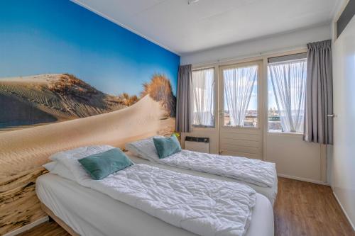 deux lits dans une chambre avec un tableau au mur dans l'établissement Appartementencomplex Juliana 126, à De Koog