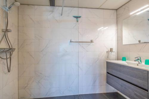 une salle de bain avec douche et lavabo dans l'établissement Appartementencomplex Juliana 126, à De Koog