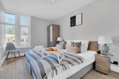 a bedroom with a bed with a tray of fruit on it at homely - King's Cross Central London Apartments in London