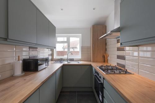 a kitchen with a sink and a stove top oven at Edgware Oasis: Modern Haven near Tube & Park in Edgware