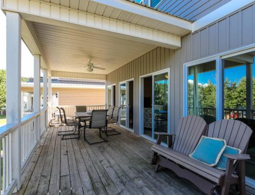 a screened porch with rocking chairs and a table at House #44 Dock Holiday (no pets) Lakefront Private Boatslip in Centre