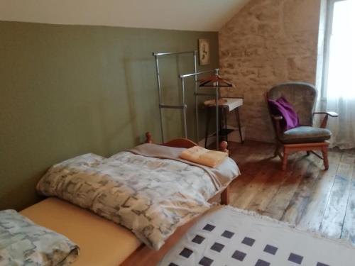 1 dormitorio con 1 cama y 1 silla en Thunder Roadhouse en La Mothe-Saint-Héray