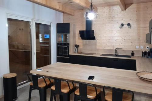a kitchen with a wooden table and some chairs at Lovely duplex with cinema room in Le Dévoluy
