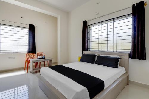 1 dormitorio con 1 cama grande y 2 ventanas en OYO Power Spirits Boarding and Lodging, en Bangalore