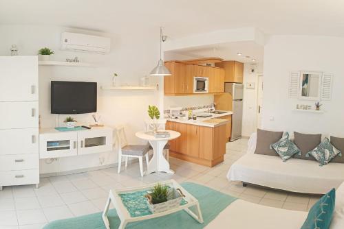 a living room and kitchen with a couch and a table at Benalbeach Holidays Benalmâdena in Benalmádena