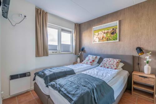 a bedroom with a bed and a window at Appartementencomplex Juliana 142 in De Koog