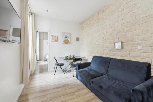 a living room with a blue couch and a table at 102-Suite Lenny - Superb apartment in Paris in Paris