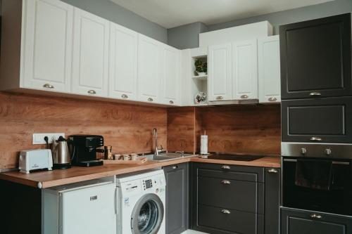 una cucina con armadietti bianchi e lavatrice di Tyulev apartment 2 a Varna