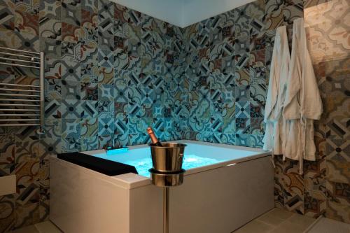 Duomo Guest House في بارليتا: حمام مع حوض مع جدار مغطى بالبلاط