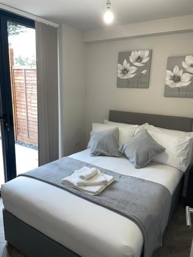 Un dormitorio con una cama con una toalla. en Modern Raynes Park Apartment x2 Bathroom*Garden*Wifi*, en Raynes Park