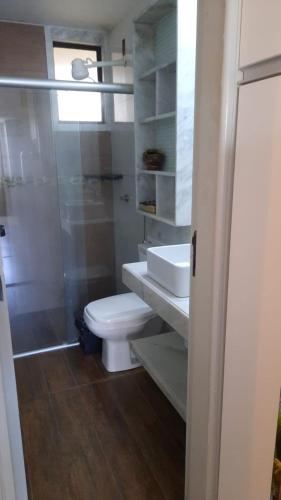 a bathroom with a toilet and a sink and a shower at Atlântico Flat in Natal