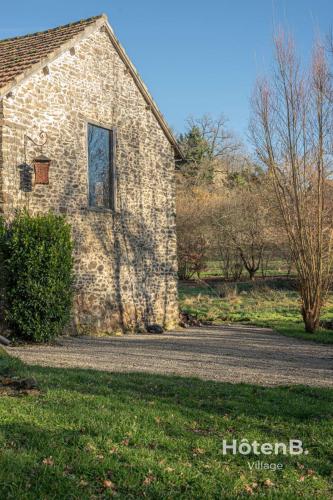 an old stone building with a window on a road at The Lajarlaud Mill - Nature & Charm Along the Water's Edge in Vareilles