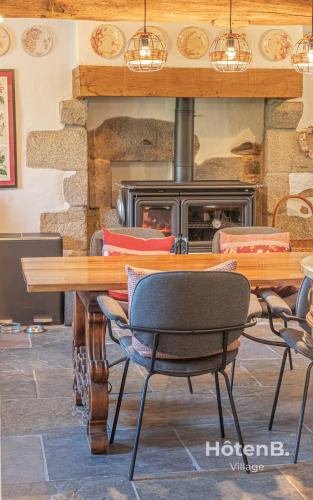 a table and chairs in front of a fireplace at The Lajarlaud Mill - Nature & Charm Along the Water's Edge in Vareilles