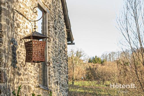 a light on the side of a stone building at The Lajarlaud Mill - Nature & Charm Along the Water's Edge in Vareilles