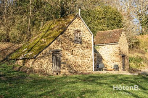 an old stone house with a grass roof at The Lajarlaud Mill - Nature & Charm Along the Water's Edge in Vareilles