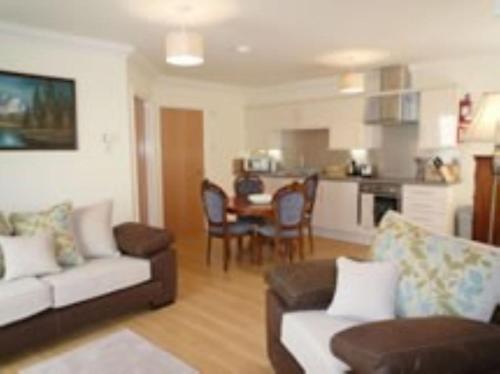 a living room with a couch and a table at Foxglove Cottage in Killean