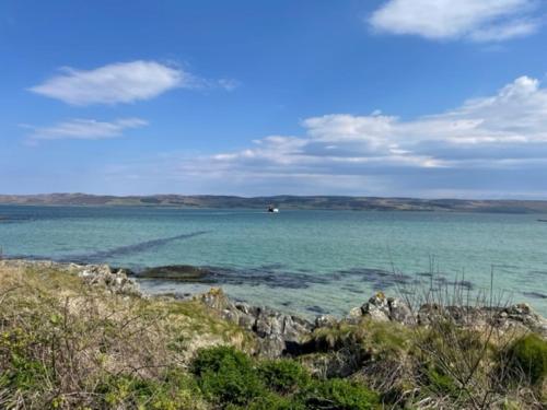 a view of the ocean with a boat in the distance at Foxglove Cottage in Killean