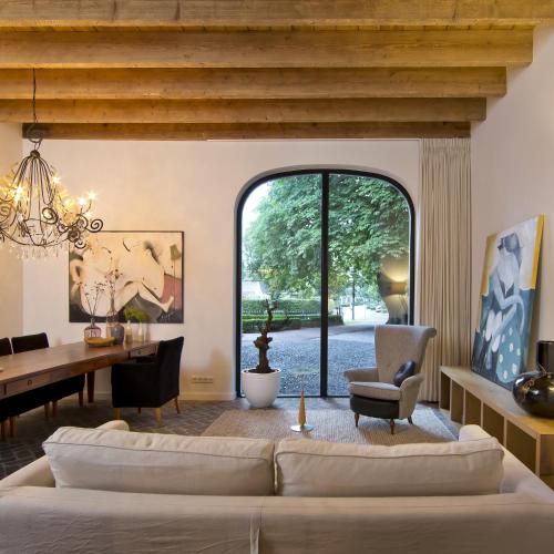 a living room with a couch and a table at Villa Polder - Boutique Hotel near Eindhoven in Gemert