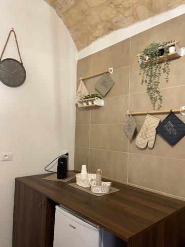 a kitchen with a counter with a clock on the wall at La Maison di Serena in Bari
