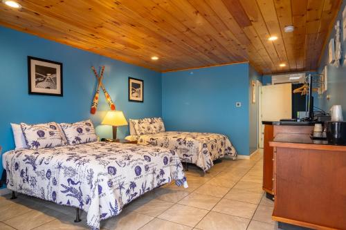 um quarto com 2 camas e uma parede azul em White Birches Motel em Ellsworth