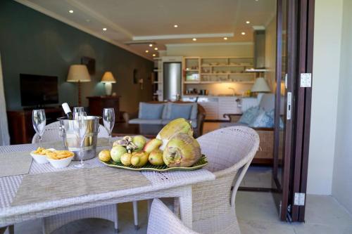 a table with a plate of fruit on top of it at Seychelles Dream House in Eden Island