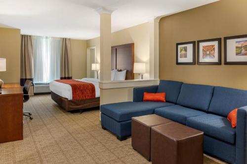 een hotelkamer met een bank en een bed bij Comfort Inn & Suites Amish Country in Gap