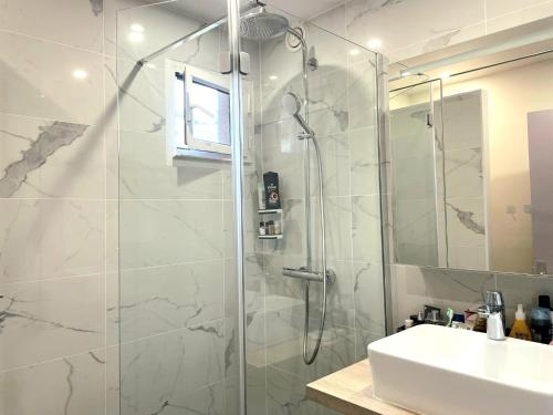 une salle de bain avec douche et lavabo dans l'établissement Appartement 3 pièces 70m² Courbevoie Paris La Défense avec Balcon, à Courbevoie