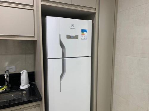 a white refrigerator in a kitchen with its door open at Flat Mobiliado - Ap 43 L Hirondelle in Campinas