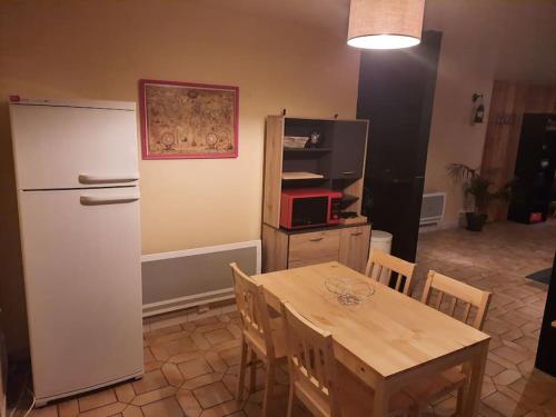 a kitchen with a dining table and a refrigerator at Appartement tout confort , centre Loudenvielle in Loudenvielle