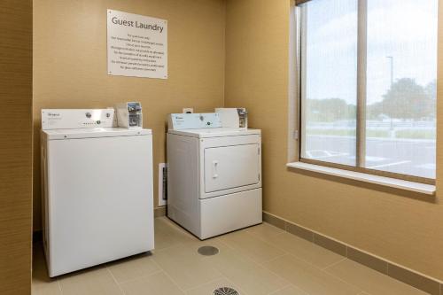 a laundry room with two machines and a window at Comfort Inn & Suites Gap Amish Country in Gap