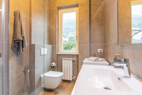 a bathroom with a sink and a toilet and a window at Appartamento Regina - Lake Como View in Gravedona