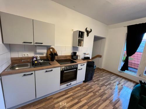 una cocina con armarios blancos y fregadero en Fewo Living Home, en Magdeburgo