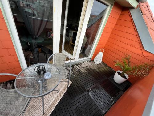 a glass table and chairs on a patio at Fewo Living Home in Magdeburg