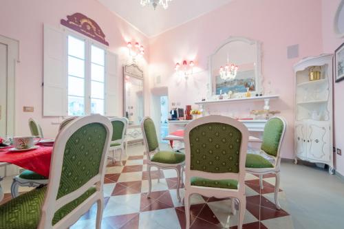 a dining room with pink walls and a table and chairs at The Crown Palace - Gallipoli in Gallipoli