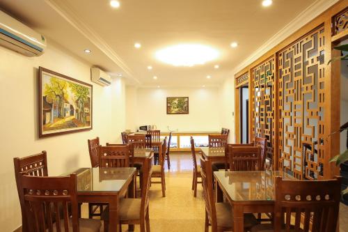 a restaurant with tables and chairs in a room at Khách Sạn 239 in Hanoi