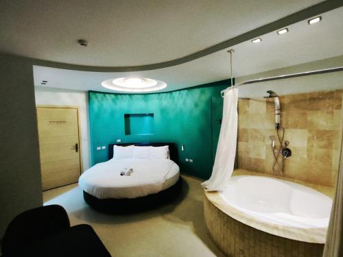 a bedroom with a bed and a bath tub at Marina Beach Hotel in Tel Aviv