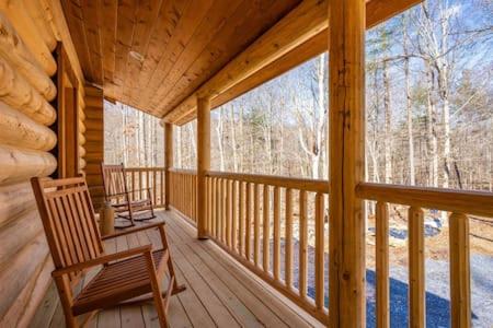 a porch of a log cabin with a rocking chair at Studio apartment at Sugarloaf Log House in Dickerson