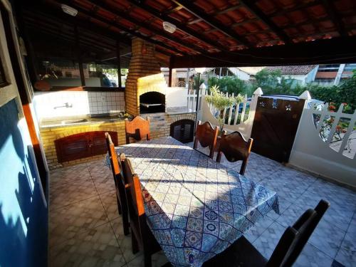 a patio with a table and chairs and a kitchen at Casa Azul na Praia do Verão Vermelho in Cabo Frio