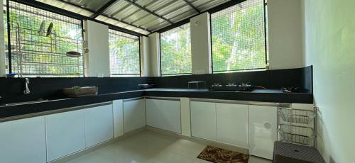 een grote badkamer met een wastafel en 2 ramen bij Lux Home Trivandrum in Trivandrum