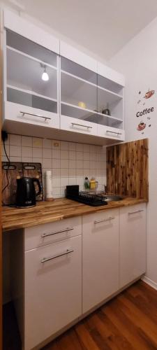 a kitchen with white cabinets and wooden counter tops at City Pension Zwickau in Zwickau