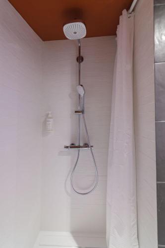 a shower in a bathroom with a shower curtain at Le Logis d'Origine. in Marly-le-Roi