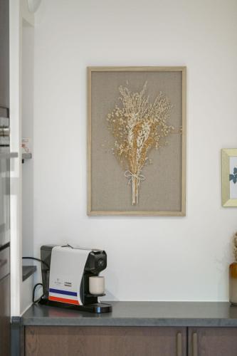 a picture hanging on a wall above a printer at Le Logis d'Origine. in Marly-le-Roi