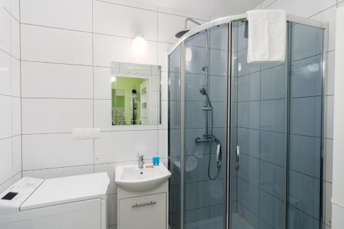 bagno bianco con doccia e lavandino di Krowoderskich Zuchów Standard Studio a Cracovia