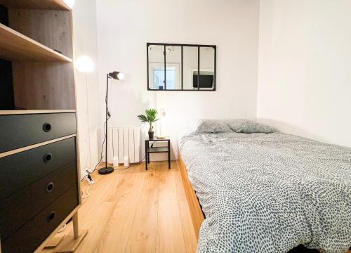 a bedroom with a bed and a dresser and a mirror at À deux pas du Trieux au cœur de la ville in Guingamp