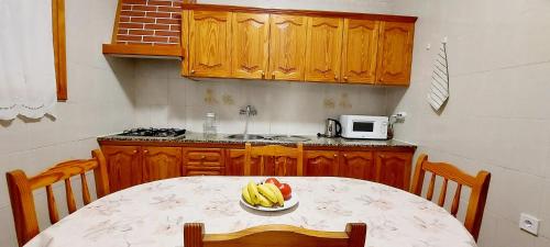 a kitchen with a table with a bowl of fruit on it at 10 km From Airport in Vecindario