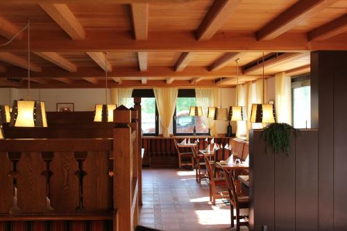 un restaurante con techos de madera, mesas y sillas en B&B Kehrerhof, en Rifiano