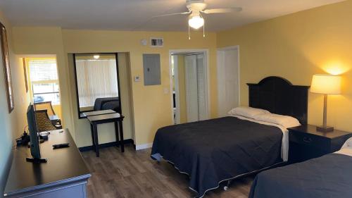 1 dormitorio con 1 cama y escritorio con lámpara en Avalon Resort of Deerfield Beach en Deerfield Beach